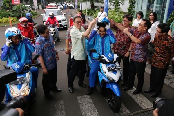 Presdir Astra International, Prijono Sugiarto memakaikan helm kepada salah satu peserta mudik. (foto : ai)