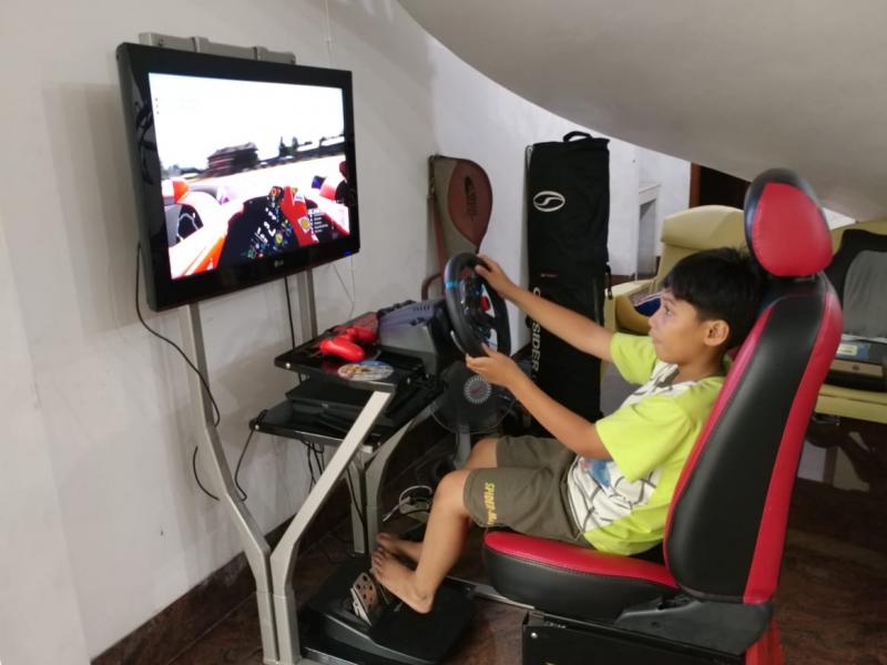 Daffa AB, menunggu saat berbuka puasa dengan bermain PS-4. (foto : budsan)