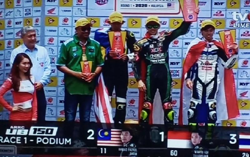 Wahyu Aji Trilaksana (angkat trofi) kumandangkan Indonesia Raya di sirkuit Sepang Malaysia. 