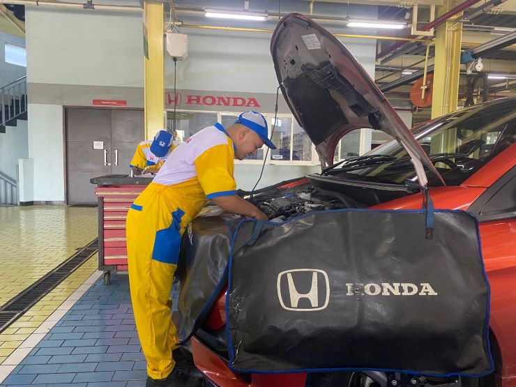 Teknisi Honda sementara melakukan pemeriksaan mobil konsumen