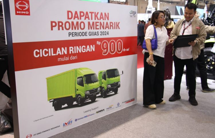 Sales Hino menawarkan promo pembelian kepada kostumer di boothnya di GIIAS 2024