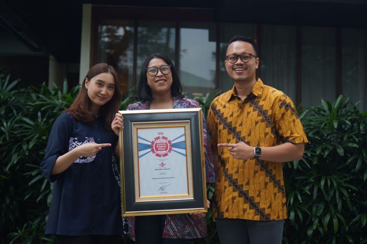 Marketing Manager PT EMLI, Ajeng Saraswati Putri didampingi perwakilan leinnya semringah mendapatkan pengargaan Indonesia Original Brand Award
