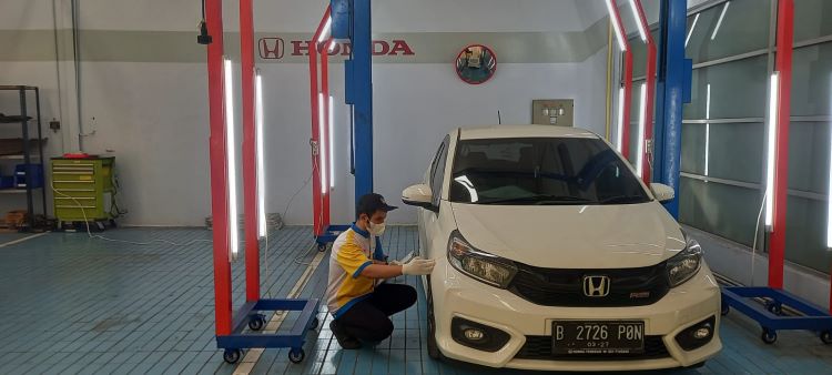 Mekanis Honda sementara memeriksa kerusakan yang terjadi pada mobil kostumer
