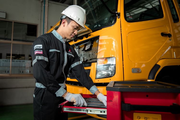 Teknisi Mitsubishi Fuso melakukan servis truk kostumer