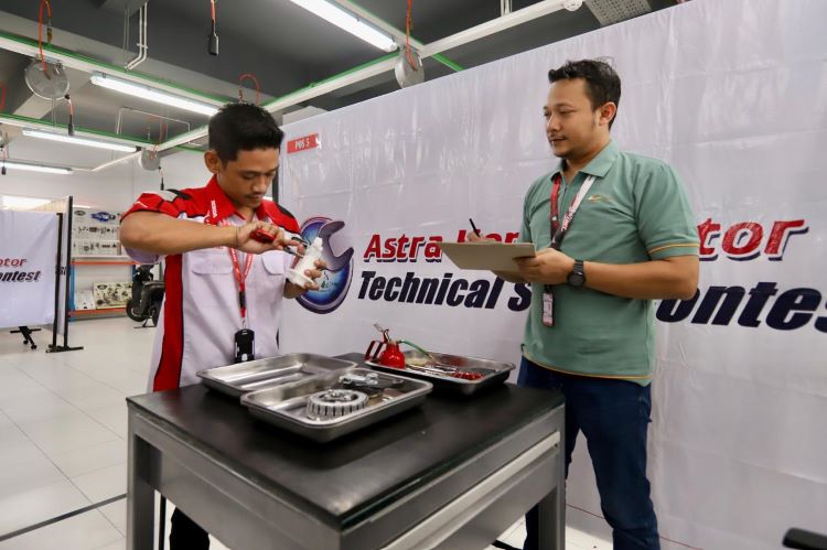 Seorang teknisi Honda sementara mengoprek komponen motor dalam Astra Honda Motor Technical Skill Contest 2024