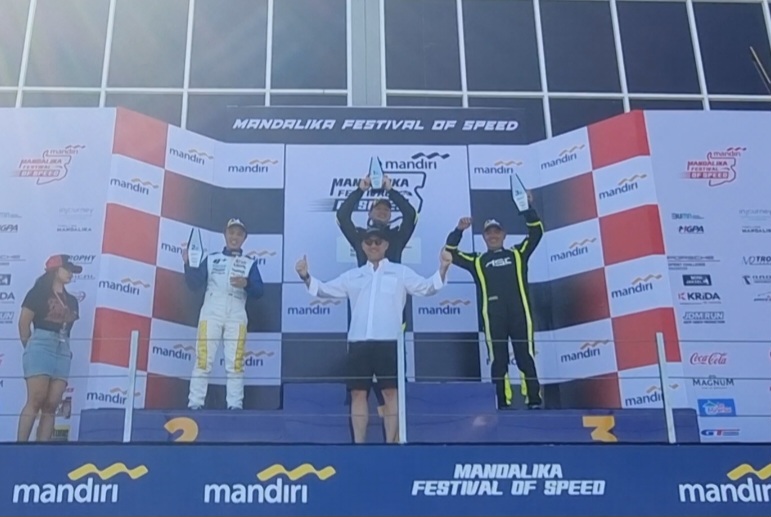Moreno Soeprapto (tengah) di podium juara balap Porsche, Ananda Mikola yang serahkan trofinya