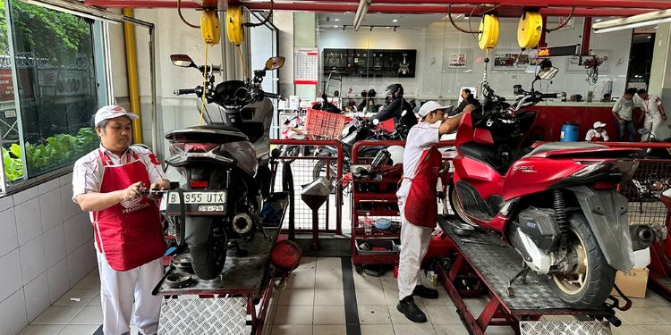 Teknisi Bengkel AHASS sementara melayani perbaikan motor kostumer Honda