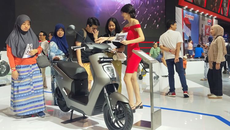 Pengunjung IMOS 2024 di Booth Astra Honda Motor yang sedang melihat motor listrk EM1 e: