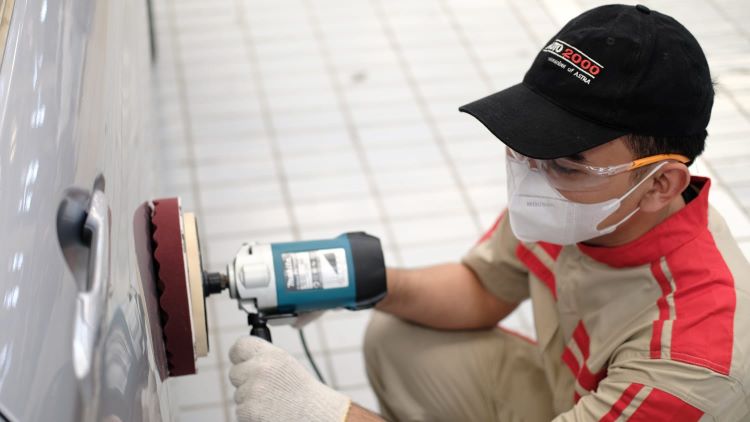 Teknisi Auto2000 sementara melakukan pemolesan mobil Toyota milik kostumer