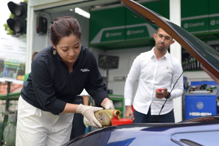 President Director Castrol Indonesia, Enjelita Jahja menuangkan pelumas pada saat seremonial partnership mereka dengan rekan bisnis baru