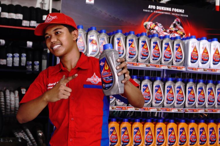 Seorang pebengkel menunjukan model oli yang asli di bengkel rekanan resmi Federal Oil