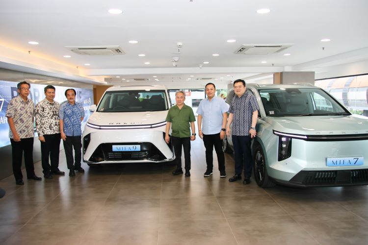 Petinggi Indomobil dan Maxus Indonesia berpose dengan dua mobil listrik Maxus saat peresmian diler pertamanya