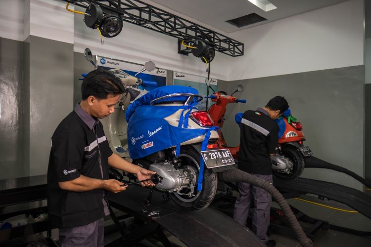 Mekanik Piaggio Indonesia sementara melakukan perawatan motor kostumer