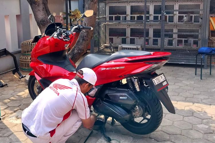 Seorang teknisi Honda memperbaiki tunggangan konsumen yang mengalami masalah 