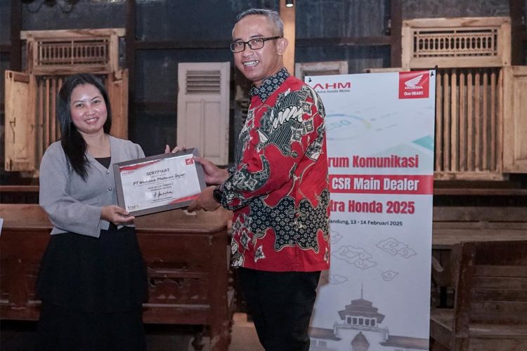 Perwakilan Wahana Honda menerima penghargaan dari Astra Honda Motor atas dedikasinya memberikan dampak positif bagi masyarakat