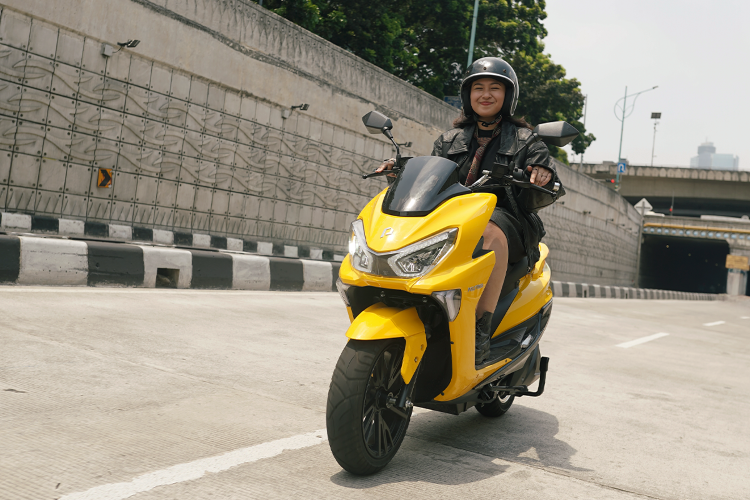 Seorang milenials menikmati perjalanannya dengan motor listrik Polytron