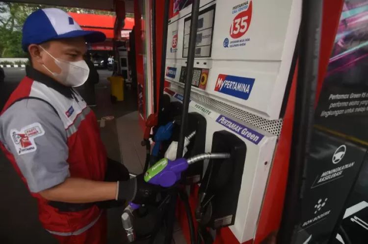 Petugas SPBU sementara melakukan pelayanan pengisian BBM ke kendaraan konsumen