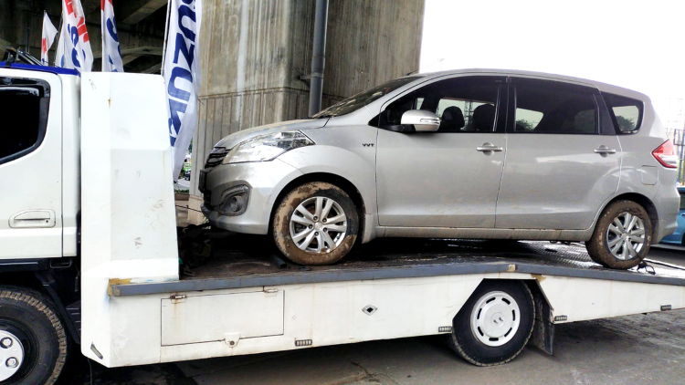 Kendaraan towing Suzuki menggendong mobil yang mati karena terendam banjir