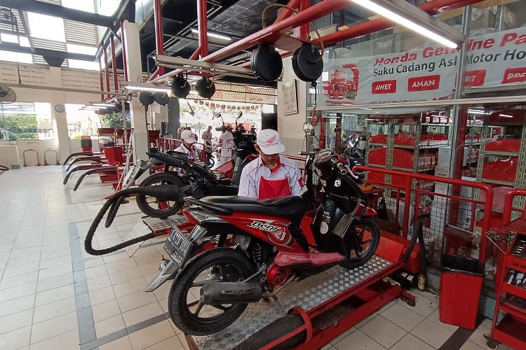 Teknisi Honda AHASS sementara melakukan perawatan terhadap motor kostumer