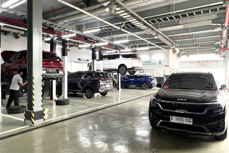 Aktivitas di bengkel resmi Kia, Seorang mekanik memeriksa dan menyervis mobl konsumen