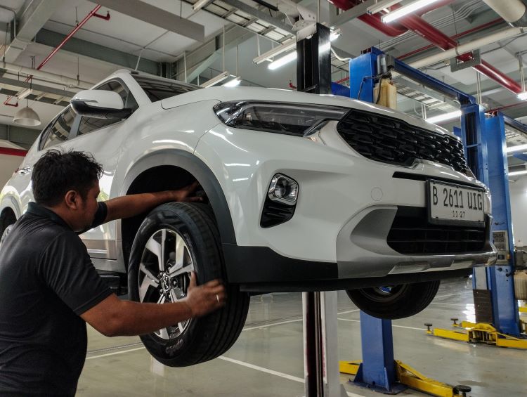 Mekanik Kia memeriksa dan melakukan perawatan terhadap mobil konsumen jelang mudik Lebaran 2025