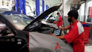 Teknisi Mitsubishi sementara melakukan perawatan mobil konsumen