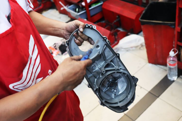 Mekanik Honda melakukan pembersihan komponen motor konsumen 