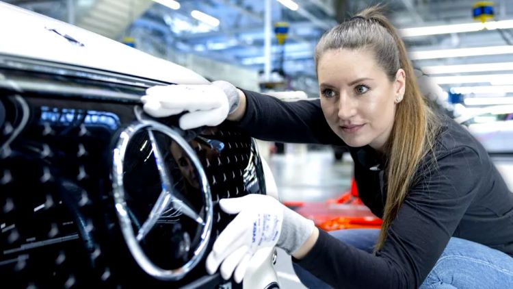 Seorang pekerja Mercedes-Benz melakukan pemeriksaan terhadap mobil produksi mereka