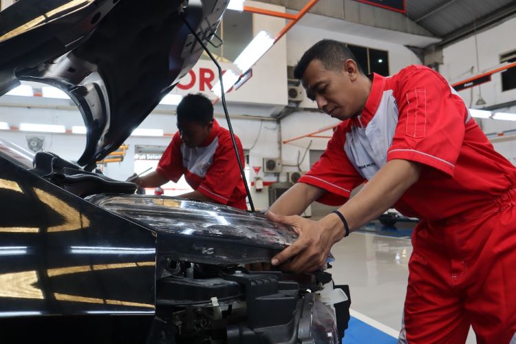 Teknisi Mitsubishi Motors melakukan pemeriksaan dan perawatan bodi dan cat mobil konsumen