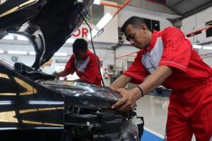 Teknisi Mitsubishi Motors melakukan pemeriksaan dan perawatan bodi dan cat mobil konsumen