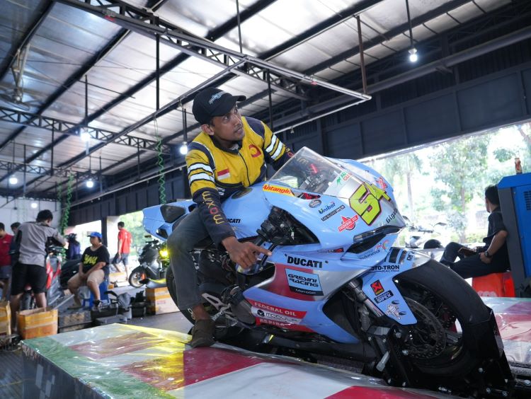Seorang kostumer mencoba sensasi menunggangi simulator Gresini Racing di Federal Oil Center 