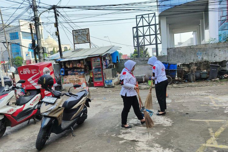 Karyawan Wari melakukan berisp-bersih di sekitar area dealer mereka