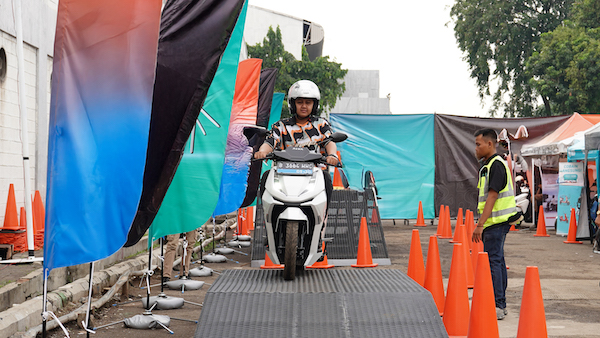 Seorang pengunjung PRJ melakukan tes ride motor listrik Alva