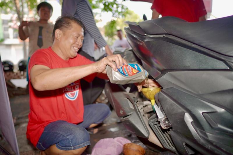 Pebengkel melakukan penggantian oli di motor konsumen dengan Federal Matic