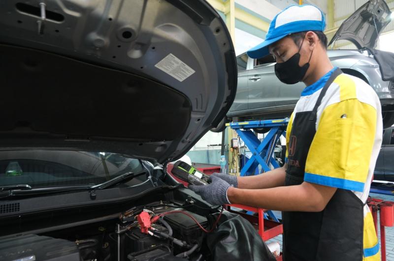 Mekanik Honda sementara melakukan servis mobil konsumen di Bengkel