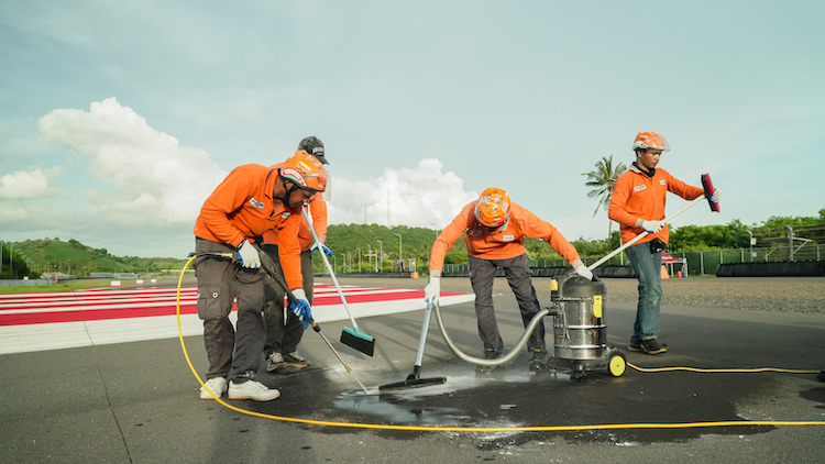 Marshal Sirkuit Mandalika membersihkan tumpahan oli di lintasan balap