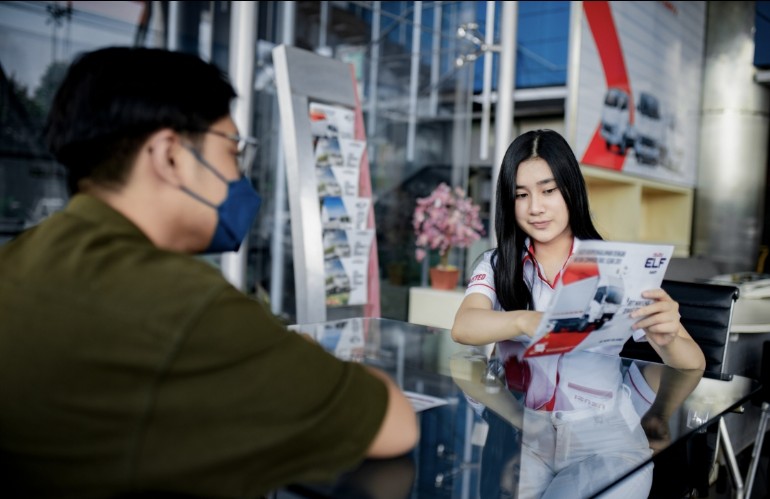 Seorang pramuniaga Isuzu sementara melayani konsumen Isuzu di dealer resmi
