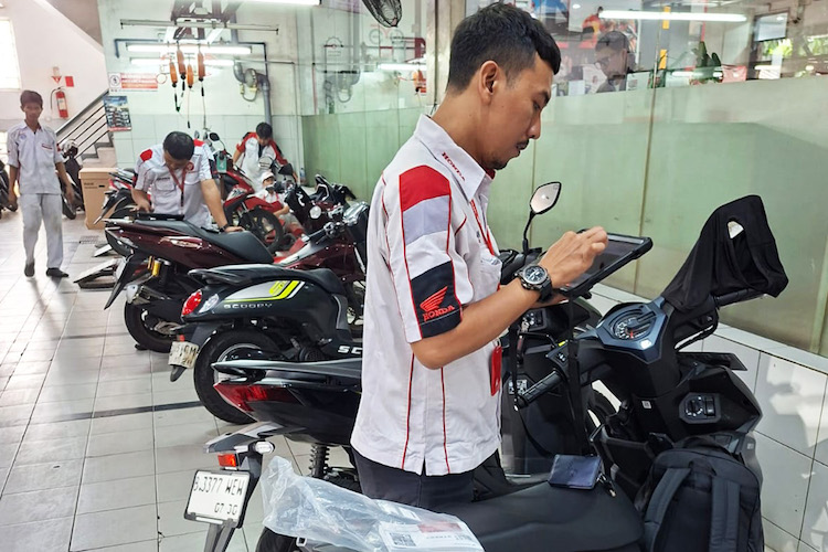 Teknisi Bengkel AHASS sementara melakukan pendataan terhadap motor konsumen yang akan servis