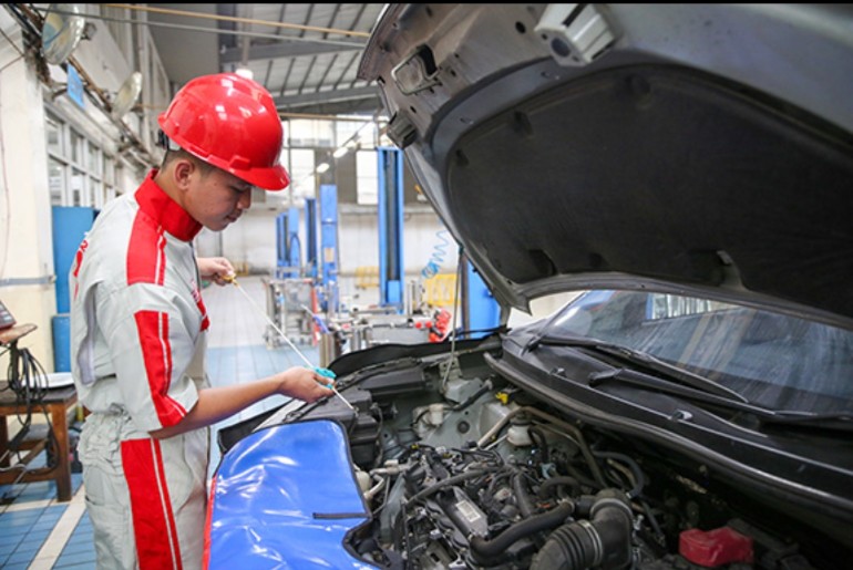 Seorang mekanik Auto2000 memeriksa kondisi kendaraan konsumen 