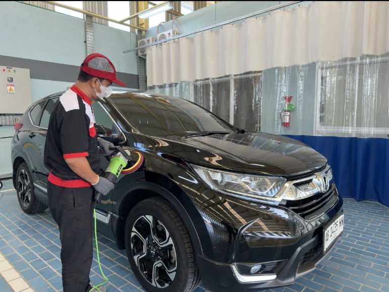Teknisi Honda sementara melakukan pemolesan bodi mobil