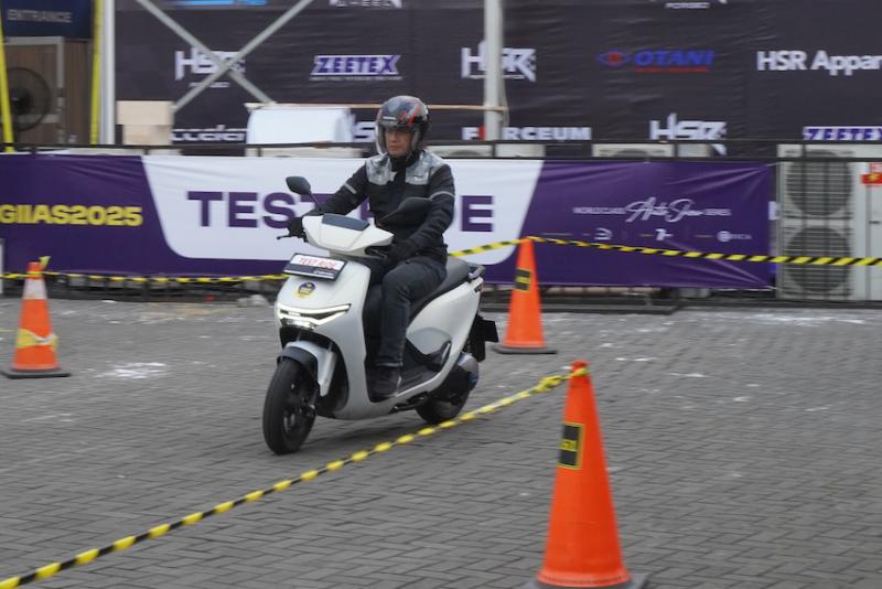 Seorang pemotor mencoba unit motor listrik Honda