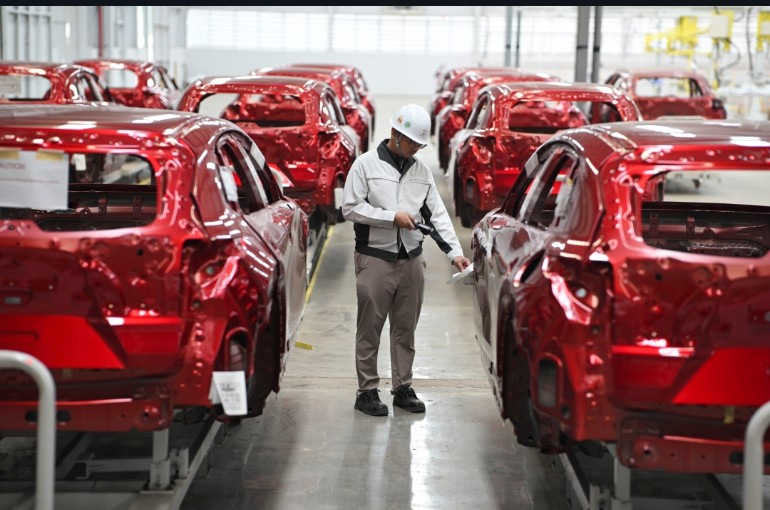 Karyawan pabrik Mazda melakukan pemeriksaan terhadap bagian bodi mobil yang baru diproduksi di Pabrik Mazda 